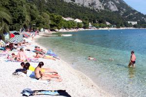 a group of people laying on a beach at Double Room Gradac 13179a in Gradac