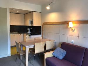 eine Küche und ein Esszimmer mit einem Tisch und einem Sofa in der Unterkunft Appartement Flaine, 2 pièces, 5 personnes - FR-1-425-175 in Arâches-la-Frasse