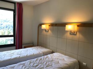 ein Hotelzimmer mit 2 Betten und einem Fenster in der Unterkunft Appartement Flaine, 2 pièces, 5 personnes - FR-1-425-175 in Arâches-la-Frasse