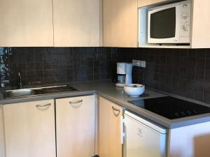 a kitchen with white cabinets and a microwave at Appartement Flaine, 2 pièces, 5 personnes - FR-1-425-175 in Arâches-la-Frasse