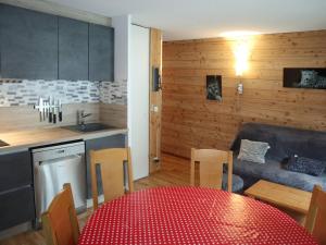 eine Küche und ein Esszimmer mit einem roten Tisch und Stühlen in der Unterkunft Appartement Les Orres, 3 pièces, 8 personnes - FR-1-322-484 in Les Orres