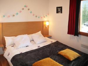 Schlafzimmer mit einem Bett mit weißer Bettwäsche und Kissen in der Unterkunft Appartement Les Orres, 3 pièces, 8 personnes - FR-1-322-484 in Les Orres
