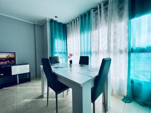 uma sala de jantar com uma mesa branca e cadeiras em PALM LIFE APARTMENT- Free Parking em Villareal