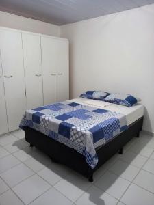 a bedroom with a bed with a blue and white blanket at Apartamento no Sítio Histórico de Olinda in Olinda