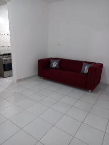 a red couch sitting on a white tiled floor at Apartamento no Sítio Histórico de Olinda in Olinda