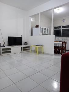 uma sala de estar com televisão e piso em azulejo branco em Apartamento no Sítio Histórico de Olinda em Olinda