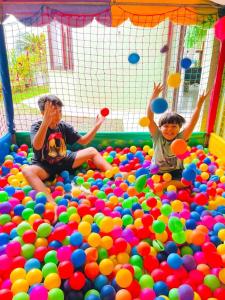due bambini che giocano in un mucchio di palle di Hostel e Pousada Bahia Beach a Itanhaém