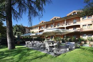 um restaurante com mesas e cadeiras em frente a um edifício em Hotel Villa Delle Rose em Pescia