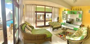 a living room with a couch and chairs and a television at Hostel e Pousada Bahia Beach in Itanhaém