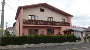 Casa rosa con balcón en una calle en Gästehaus Eva, en Nová Lesná