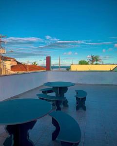 a group of picnic tables on top of a patio at Hostel e Pousada Bahia Beach in Itanhaém