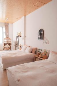 2 camas en una habitación con paredes blancas en Privacy Home, en Tainan