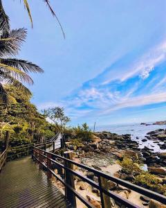 a wooden boardwalk leading to a beach with the ocean at Hostel e Pousada Bahia Beach in Itanhaém