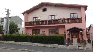 Casa rosa con balcón en una calle en Gästehaus Eva, en Nová Lesná