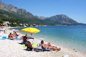 un gruppo di persone sedute sulla spiaggia di Apartments and rooms by the sea Zaostrog, Makarska - 2661 a Zaostrog