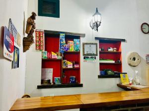 a room with red shelves and a wooden table at Hotel San Gabriel in El Cocuy