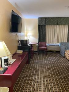 um quarto de hotel com uma secretária e uma cama e um quarto em America's Stay Inn Stewartville em Stewartville