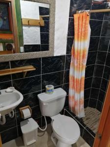 łazienka z toaletą i umywalką w obiekcie Aparthotel Oleaje w mieście Mompiche