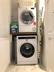 a washer and dryer in a small laundry room at Homely Victorian Terraced Town House with Parking. in Taunton