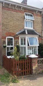 una casa de ladrillo con una valla de madera delante de ella en Homely Victorian Terraced Town House with Parking., en Taunton