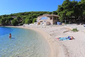 a group of people laying in the water on a beach at Double Room Rogoznica 3097a in Rogoznica +6 photos