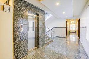 a hallway with a tile wall and a staircase at Sai Vidisha Palace in Shirdi