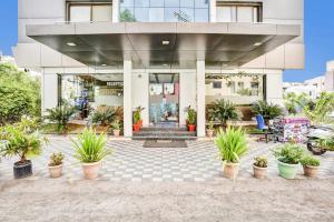 a building with potted plants in front of it at Sai Vidisha Palace in Shirdi