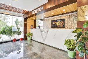 a lobby of a restaurant with potted plants at Sai Vidisha Palace in Shirdi