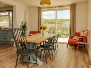 a kitchen and dining room with a wooden table and chairs at Pepperpots in Newquay