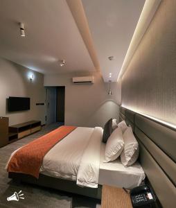 a bedroom with a bed and a tv on the wall at Hotel Omni Residency Dhaka in Dhaka