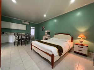 a bedroom with a bed and a kitchen with a table at Beach Garden Hotel in Saipan