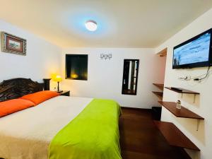 a bedroom with a large bed and a flat screen tv at Hotel San Gabriel in El Cocuy +138 photos