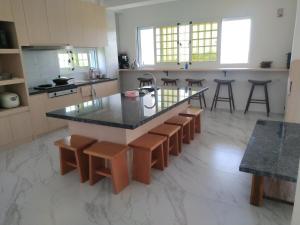 a kitchen with a island with stools and a counter top at Diamond Avenue Homestay in Changbin