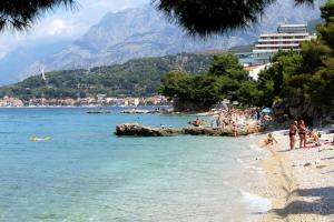 eine Gruppe von Menschen an einem Strand in der Nähe des Wassers in der Unterkunft Apartments by the sea Podgora, Makarska - 16476 in Podgora