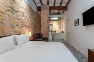 a bedroom with a white bed and a brick wall at Tosca 2 PAX by costablancarent in Denia