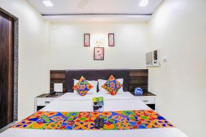TurambheにあるFabExpress The Grand Kohinoor Navi Mumbaiのベッドルーム1室(カラフルな掛け布団付きのベッド1台付)