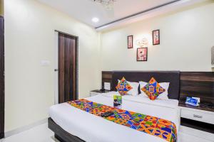 een slaapkamer met een bed en een bureau bij FabExpress The Grand Kohinoor Navi Mumbai in Turambhe