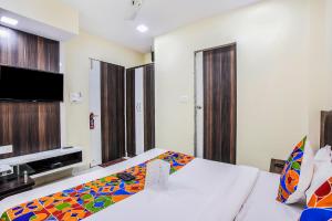 Habitación de hotel con cama y TV en FabExpress The Grand Kohinoor Navi Mumbai, en Turambhe