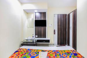 TurambheにあるFabExpress The Grand Kohinoor Navi Mumbaiのベッドとデスクが備わる客室です。