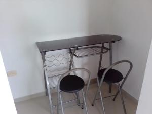 einen Schreibtisch mit zwei Hockern unter einem Tisch in der Unterkunft Bonito apartamento en Cartagena con garaje gratuito in Cartagena de Indias