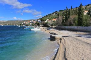 a sandy beach with boats in the water at Apartments by the sea Zatoglav, Rogoznica - 17321 in Rogoznica