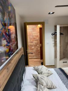 1 dormitorio con cama y pared de ladrillo en SOLYMAR PONIENTE Apartamento Recién Reformado A 3 min de Playa Poniente y del Centro Parking Opcional, en Benidorm