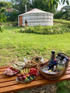 a picnic table with baskets of food and drinks at Jurta pod Blaníkem 
