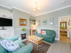 a living room with two blue couches and a table at Tor View Fourwinds in Okehampton