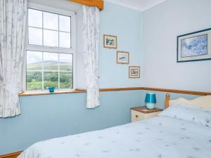 a bedroom with a bed and a window at Brokan Fourwinds in Okehampton