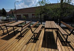 a picnic table and benches on a wooden deck at Sport Klub Hvozd in Hvozd