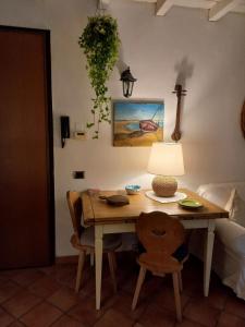 uma mesa de madeira com um candeeiro e uma cadeira em La casetta nel verde em Ronago