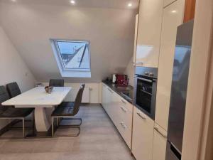 Una pequeña cocina con una mesa y una ventana. en B01 Apartment between Cologne & Bonn with nature access, en Troisdorf