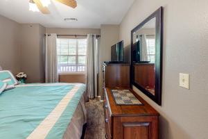 um quarto com uma cama e uma cómoda com um espelho em Woodpecker Watchtower em Branson