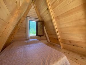 Bett in einem Holzzimmer mit Fenster in der Unterkunft A Frame Cottage in Varjanisi - Batumi in K'eda